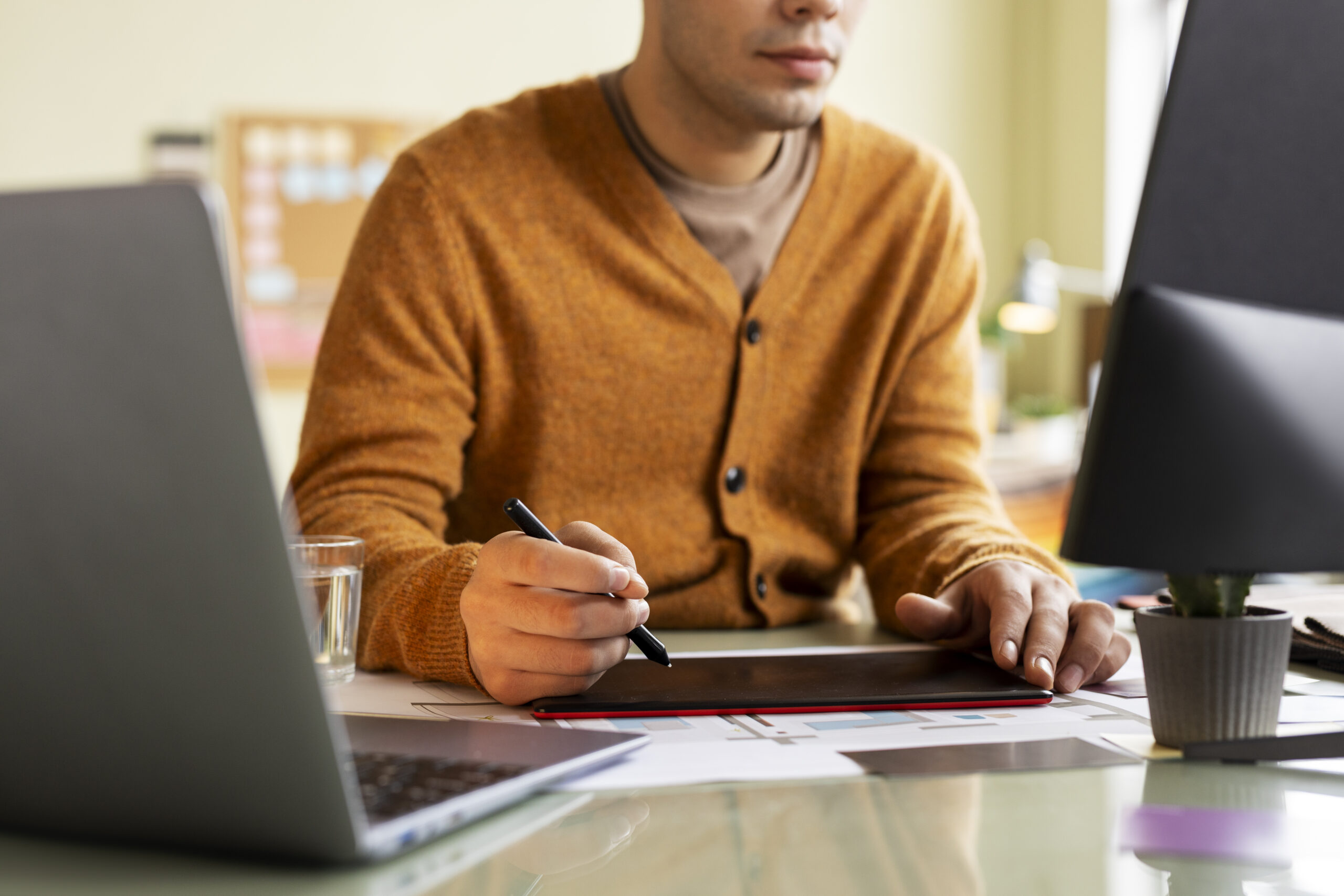 Man in orange cardigan designing CAD software automation